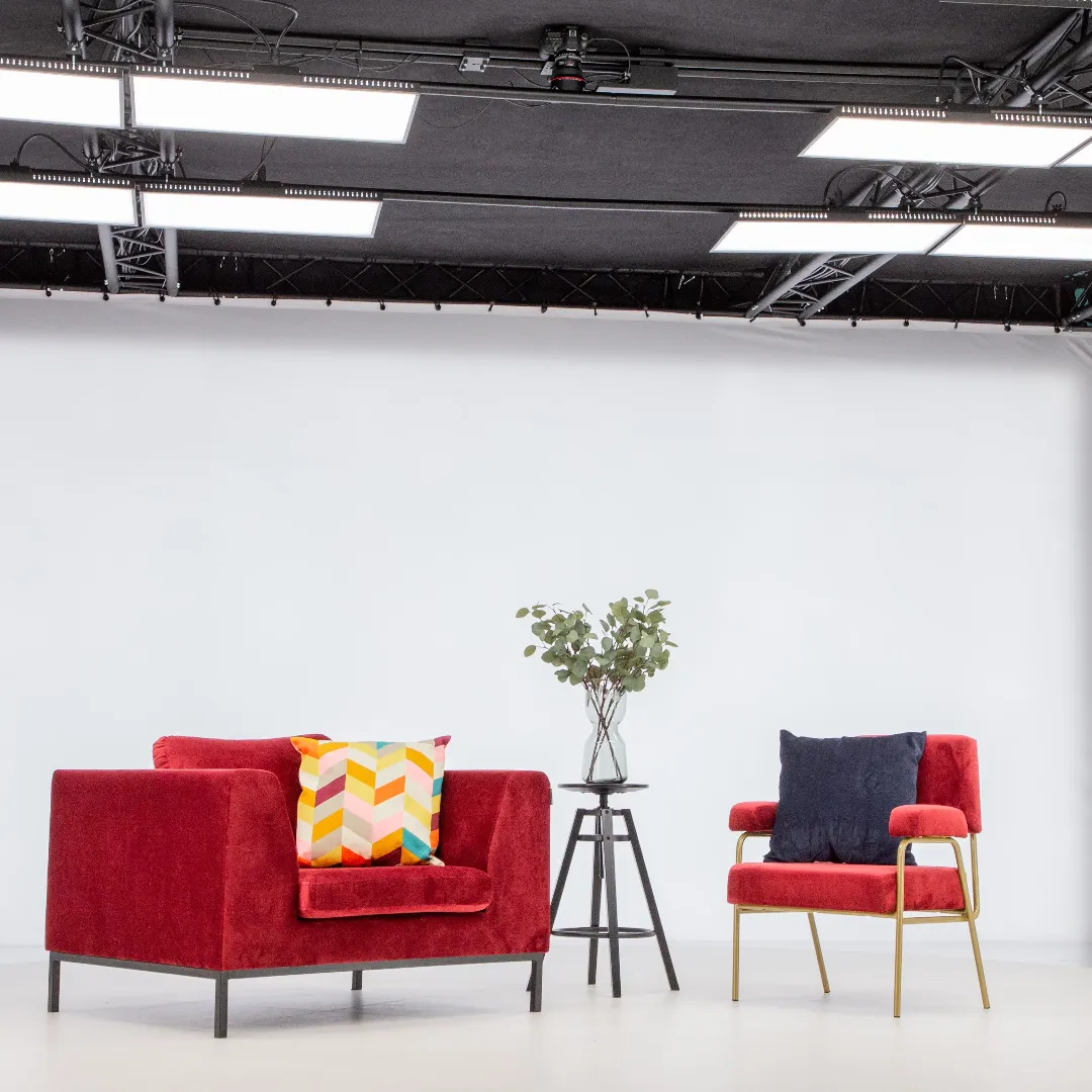 Sillones rojos modernos y mesa auxiliar en un estudio fotográfico profesional